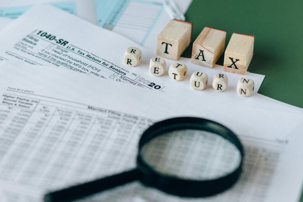Tax return forms with wooden blocks spelling 'TAX RETURN', representing 2025 IRS updates and changes under the One Big Beautiful Bill